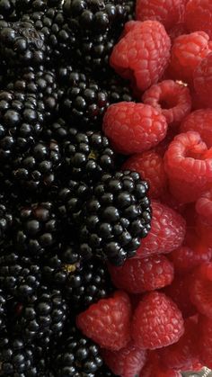 raspberries and blackberries are piled on top of each other