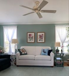 a living room with two couches and a ceiling fan in the middle of it