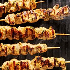 several skewers of meat cooking on a grill