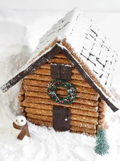 a gingerbread house with a wreath on the door and snow covered roof is shown