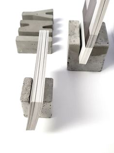 some concrete blocks are stacked on top of each other and one is holding a piece of paper