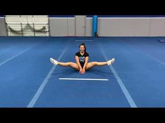 a woman is sitting on the floor doing stretching exercises