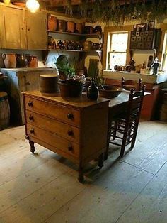 an old fashioned kitchen with many pots and pans on the counter top in it