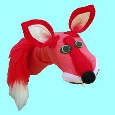 a red and white stuffed animal head on a light blue background with the eyes open