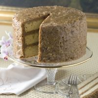 a cake with one slice missing from it on a glass plate next to a fork and napkin