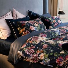 a bed with floral comforter and pillows on it