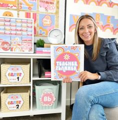 a woman sitting on a chair holding up a sign that says teacher planner in front of her