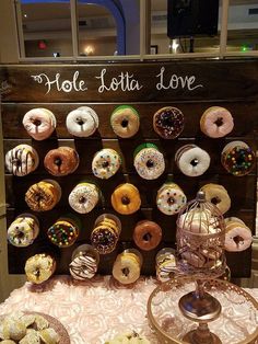 a table topped with lots of donuts next to a sign that says hole latta love