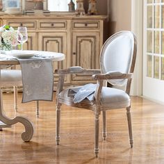 a dining room table with two chairs and a vase on it