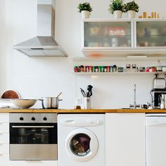 a white kitchen with an oven, sink and dishwasher in it's center