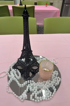 the eiffel tower is next to a candle holder on a pink table cloth