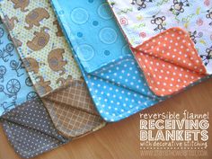 several baby bibs are laid out on a wooden surface with the words reversible flannel receiving blankets