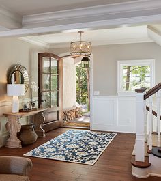 an instagramted photo of a living room with stairs and rugs on the floor