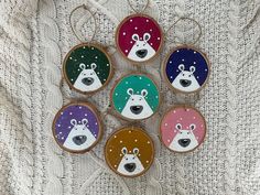 six decorated cookies are arranged in the shape of polar bear and reindeer heads on a white sweater