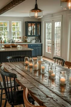 a wooden table with candles on top of it in front of an open kitchen area