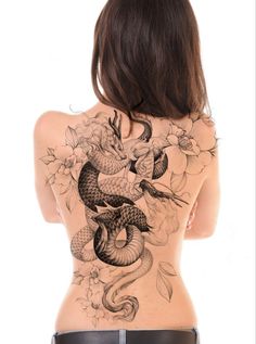 the back of a woman's body with tattoos on her stomach and an image of a snake