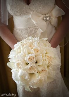 a bride holding a bouquet of white flowers