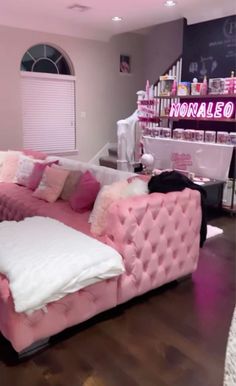 a pink couch sitting on top of a hard wood floor next to a white table