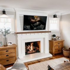 a living room with a fire place in the center and a flat screen tv above it