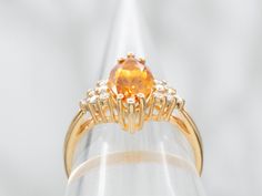 The warm, orange shade of this variety of citrine is absolutely exquisite. This particular piece is an excellent example, full of sparkle and with excellent color. We've set this marquise cut stone into a vintage mounting with sparkling diamond accents on the shoulders. Metal: 14K Yellow GoldGem: Citrine 1.51 CaratsGem Measurements: 11.2 x 5.9 mm, Marquise CutAccents: 12 Diamonds totaling .18 Carats, H-I in Color, SI-I in ClarityRing Size: 6.25Marks: "14K" Stamped on the inside band