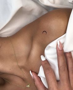 a woman laying in bed with her hand on the side of her stomach and wearing a ring