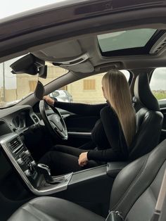 a woman sitting in the driver's seat of a car