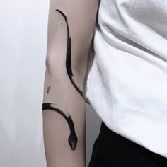 a woman's arm with a black snake tattoo on the left side of her arm