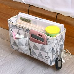 an organized storage bag sitting on the floor next to a bed