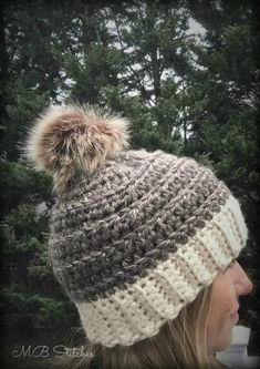 a woman wearing a knitted hat with a pom - pom