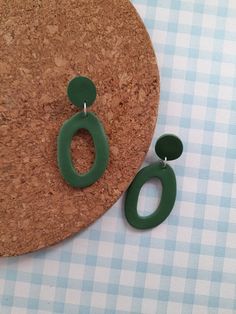 Dark green coloured organic oval donut earrings handmade from polymer clay. Perfect for autumn. The circle stud has a baked in stainless steel earrings post. Approx 5.5cm long Available in more colours. Check out my other items: https://www.houseofhettyj.etsy.com Emerald Clay Earrings, Minimalist Green Polymer Clay Earrings, Green Clay Earrings, Green Dangle Clay Earrings, Olive Green Clay Earrings, Playful Green Polymer Clay Jewelry, Green Hand-painted Polymer Clay Earrings, Donut Earrings, Autumn Earrings