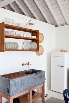 a kitchen with a sink and shelves filled with dishes