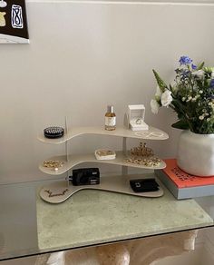 there is a vase with flowers on top of the table and other items in front of it