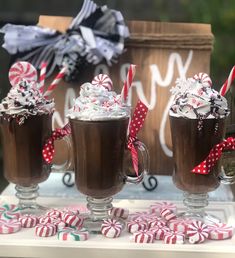 three glasses filled with hot chocolate and candy canes