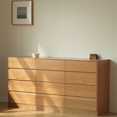 a wooden dresser sitting next to a white wall