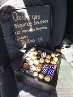 a box filled with assorted chocolates sitting in the back seat of a car