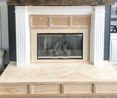 a fireplace is being built in a living room with white paint and wood trimming