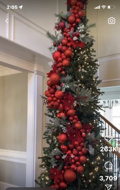 the christmas tree is decorated with red and silver ornaments