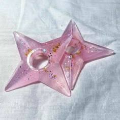 a pink star shaped object sitting on top of a white sheet