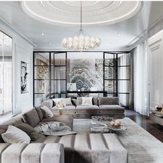 a black and white photo of a living room with couches, coffee table and chandelier