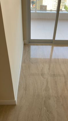 an empty room with sliding glass doors and marble flooring in front of the window