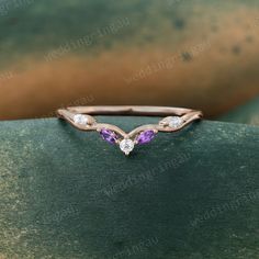 a diamond and amethyst ring on a green surface