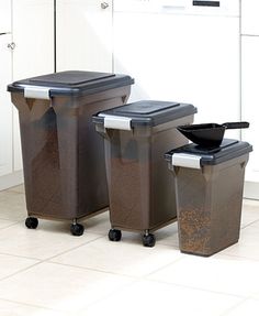 three trash cans sitting next to each other in a kitchen