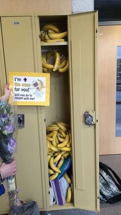 a person holding flowers and standing in front of a locker with bunches of bananas