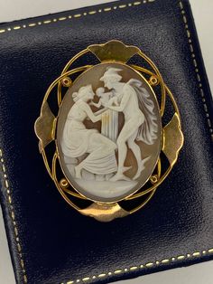 An elegant oval cameo brooch. This beautiful cameo has been carved from Cornelian shell. These shells have a white marble like layer and a darker layer, typically brown. Allowing a master carver to create this image of a beautiful lady in fine detail with a contrasting background. This cameo is mounted in a yellow gold setting featuring a decorative rope twist boarder and fastens with a secure roll-over pin and safety chain pin to the back. This brooch is the exclamation mark to any lapel.  Weight: 9.59g Length: 45mm Width: 37mm Sale price: £295.00 White Cameo Brooch For Formal Occasions, White Cameo Brooches For Formal Occasion, Antique Oval Carved Brooches, White Oval Cameo Brooches, Collectible Oval Cameo Brooch, Collectible Oval Cameo Brooches, Classic Oval Cameo Brooch, Antique Oval Cameo Brooch, Antique White Cameo Brooch