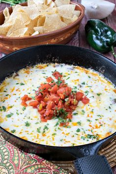 tortilla dip in a black skillet with chips and salsa on the side