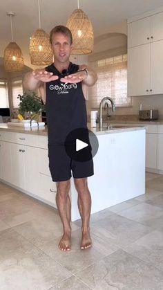 a man standing in front of a kitchen counter with his hands out to the side