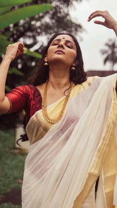 a woman in a sari holding her hands up