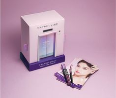 a purple box with an image of a woman's face on it next to some makeup products