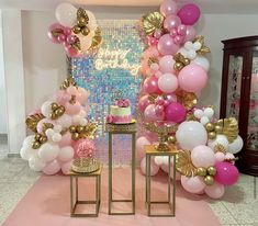 pink and gold balloons are on display at a birthday party with a cake, table and chairs