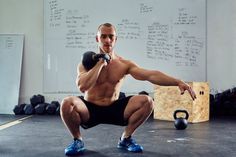 a man squats while holding two kettles in his hands, with one hand on the ground